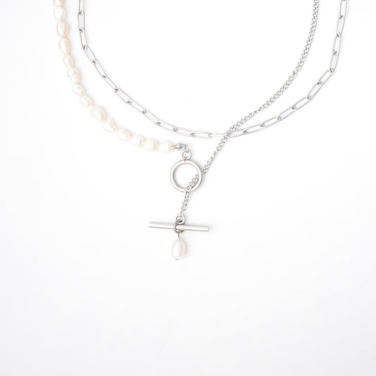 Silver necklace with pearls and textured chains with a toggle clasp and pearl pendant on a white background
