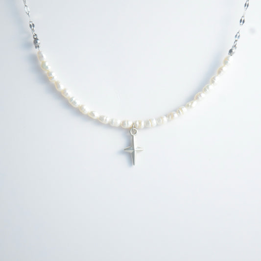 Silver pearl choker necklace with a small north star pendant on a light gray background