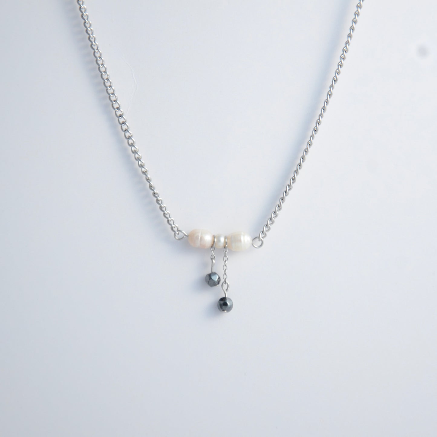 Silver necklace with a bow made of pearls and glass beads