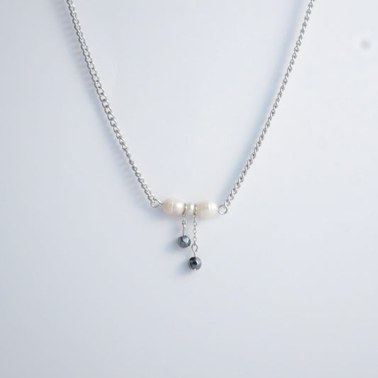 Silver necklace with a bow made of pearls and glass beads