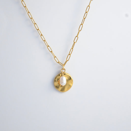 Gold paperclip necklace non-tarnish with a round sun pendant and a pearl on a light gray background