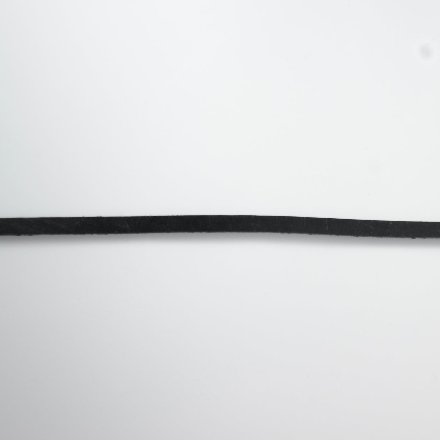 Black leather choker necklace on a light gray background