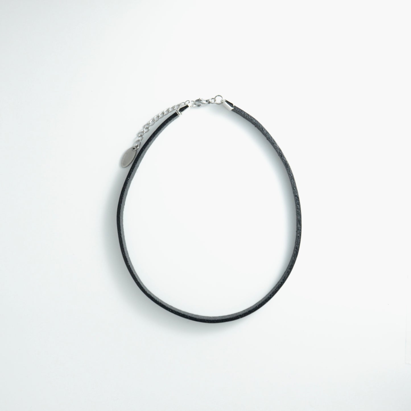 Black leather choker necklace on a light gray background