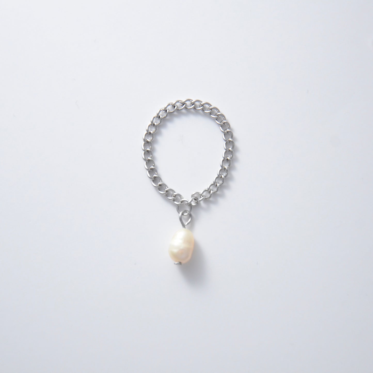 Silver stainless steel dainty chain ring with a pearl charm on a white background