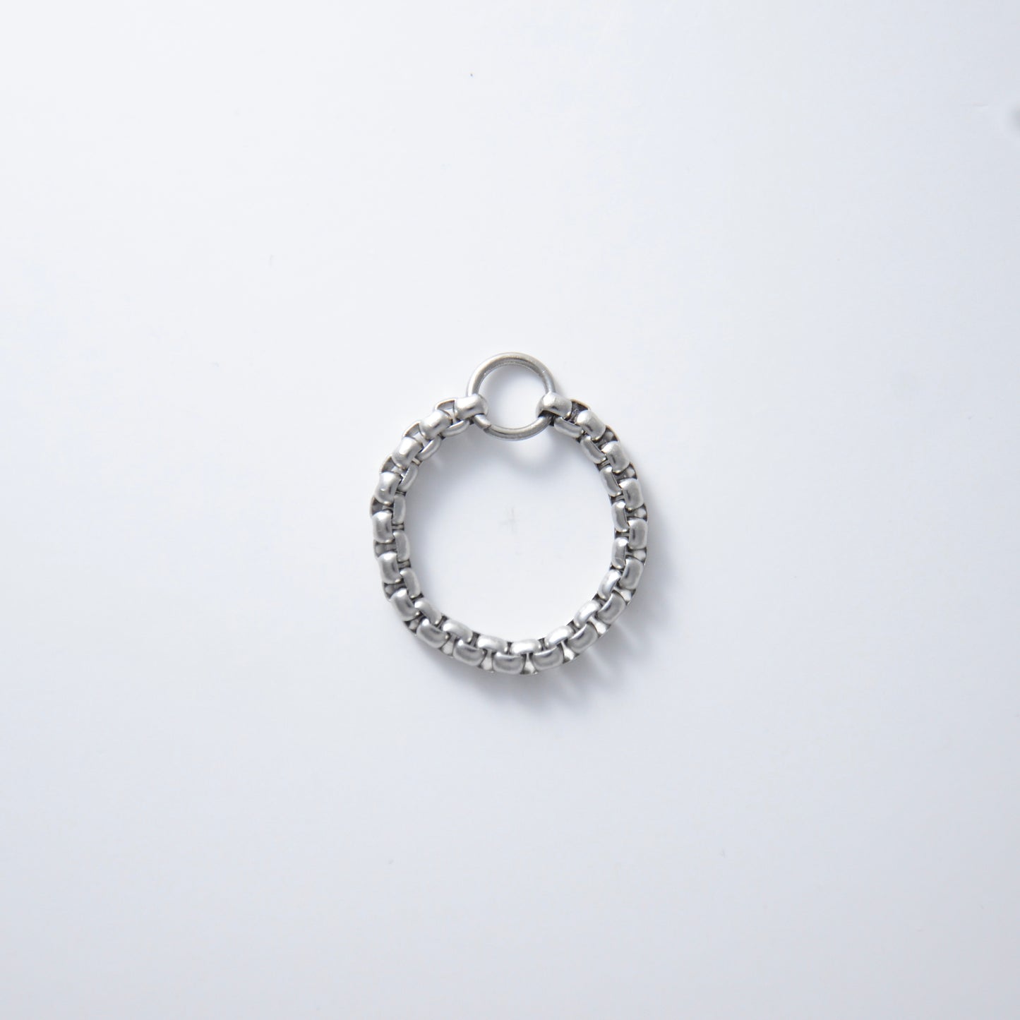 Silver stainless steel braided box chain ring on a white background