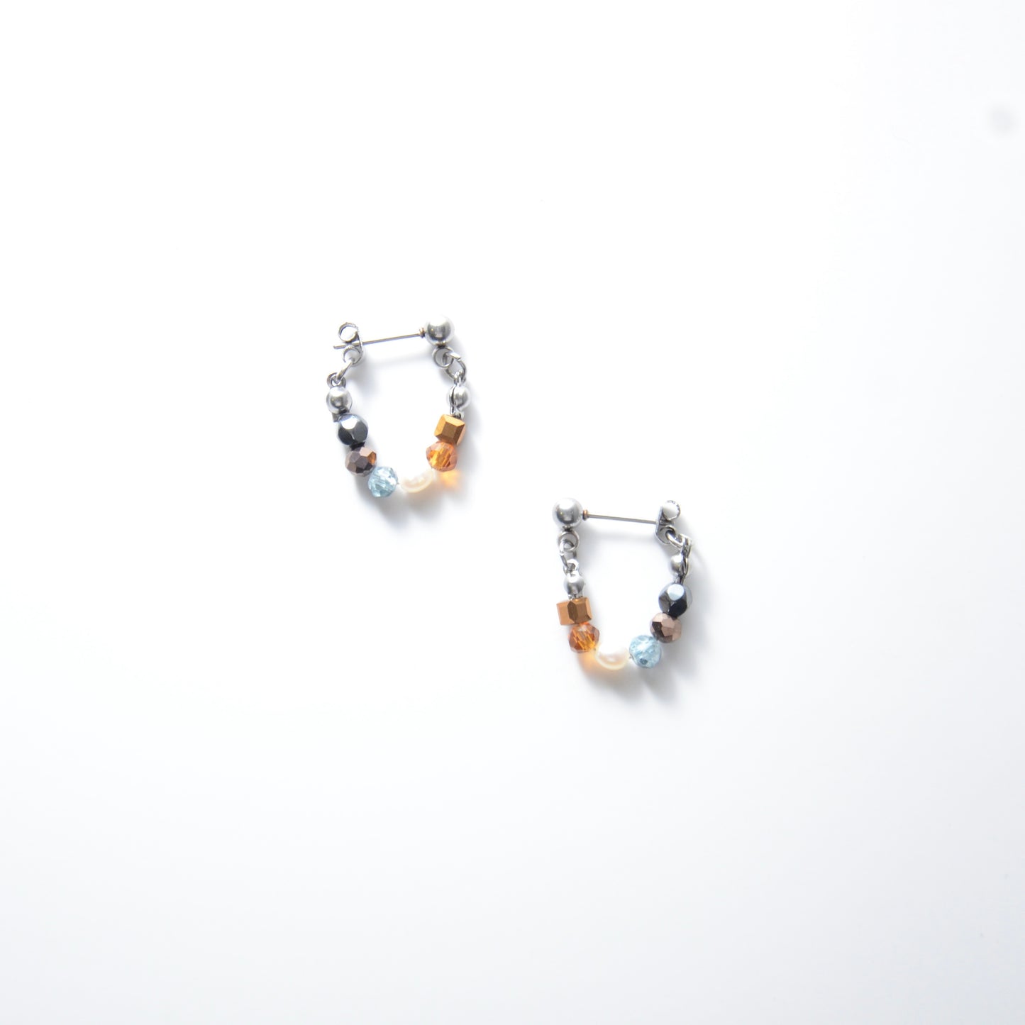 Pair of stainless steel beaded hoop earrings on a white background