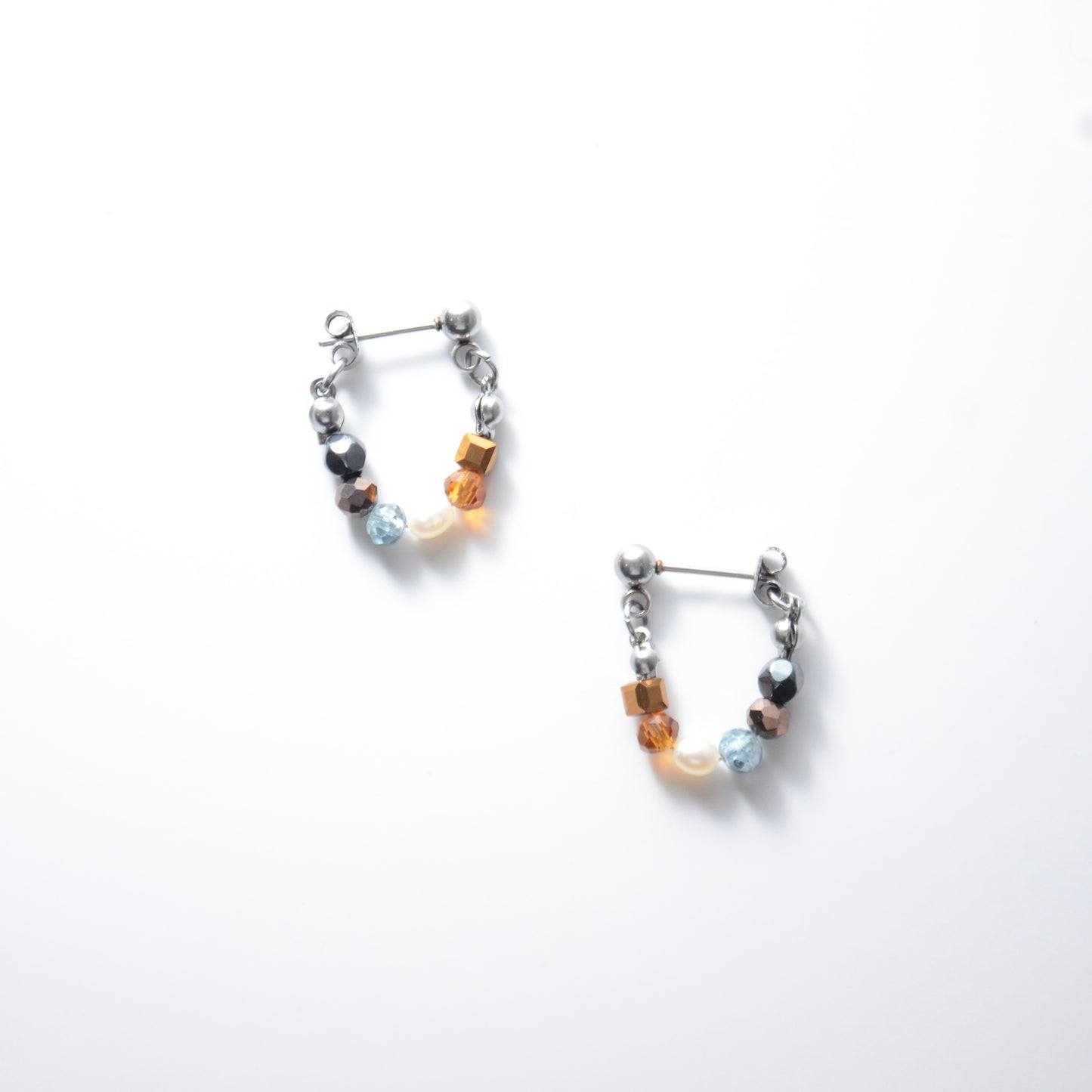 Pair of stainless steel beaded hoop earrings on a white background