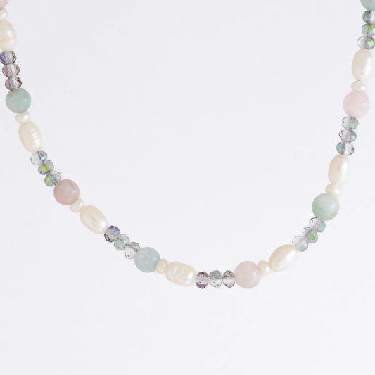 Beaded necklace with pearls and glass beads on a light gray background