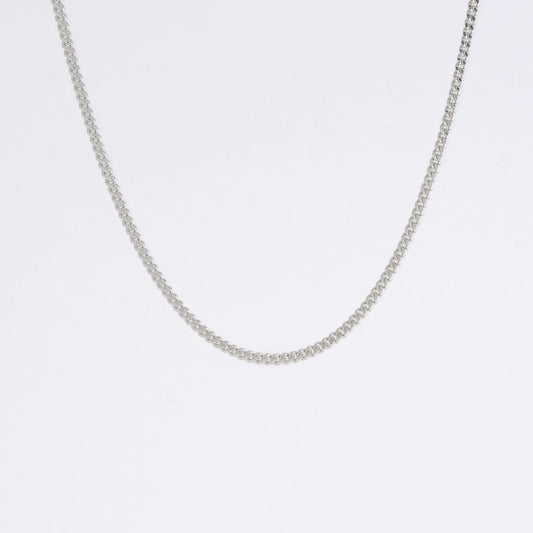 Silver curb chain necklace on a light gray background