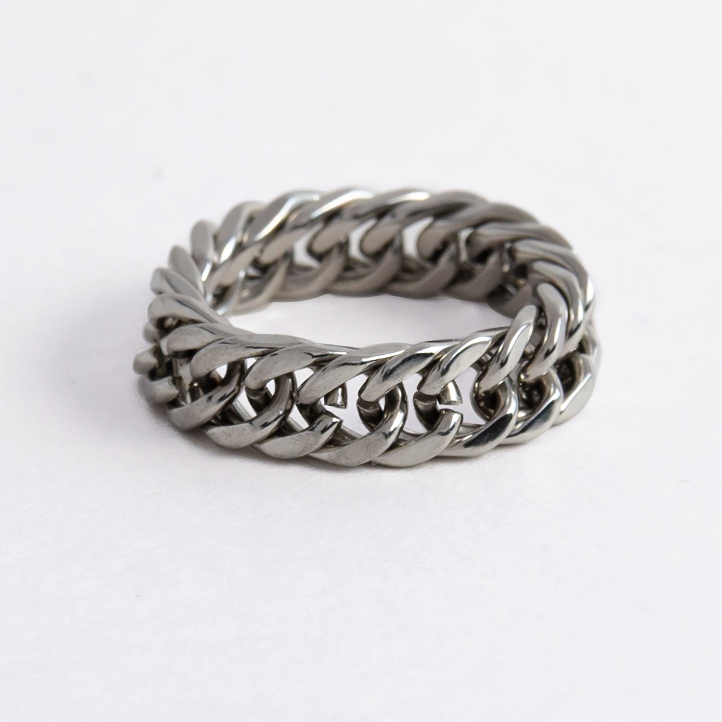 Silver braided cuban chain stainless steel ring on a white background