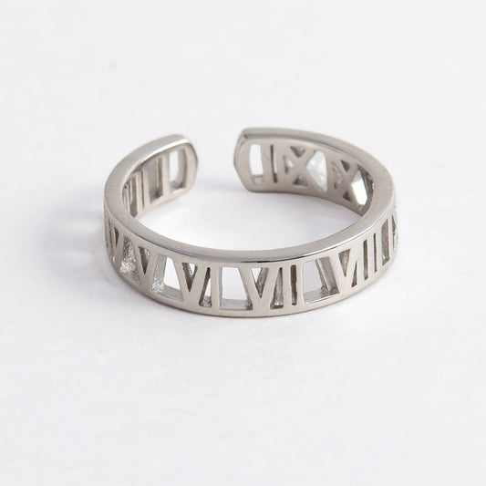 Silver ring with Roman numeral design on a light gray background