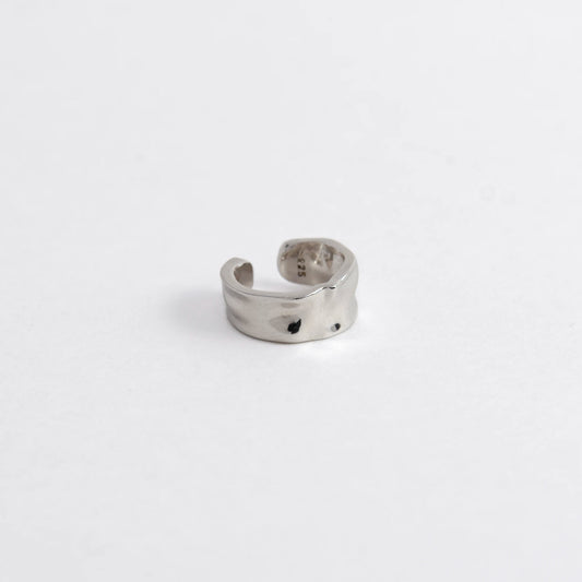 Silver ear cuff on a light gray background
