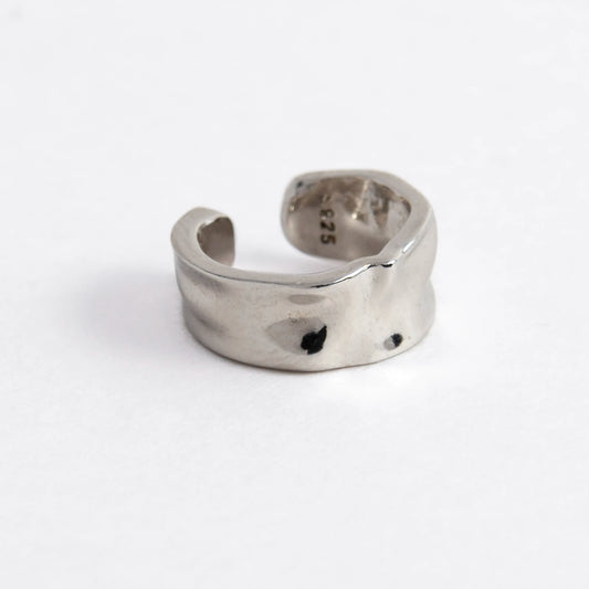 Silver ear cuff on a light gray background