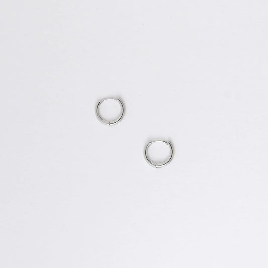 Two silver hoop earrings on a light gray background