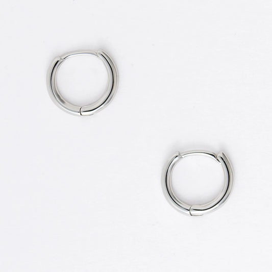 Two silver hoop earrings on a light gray background