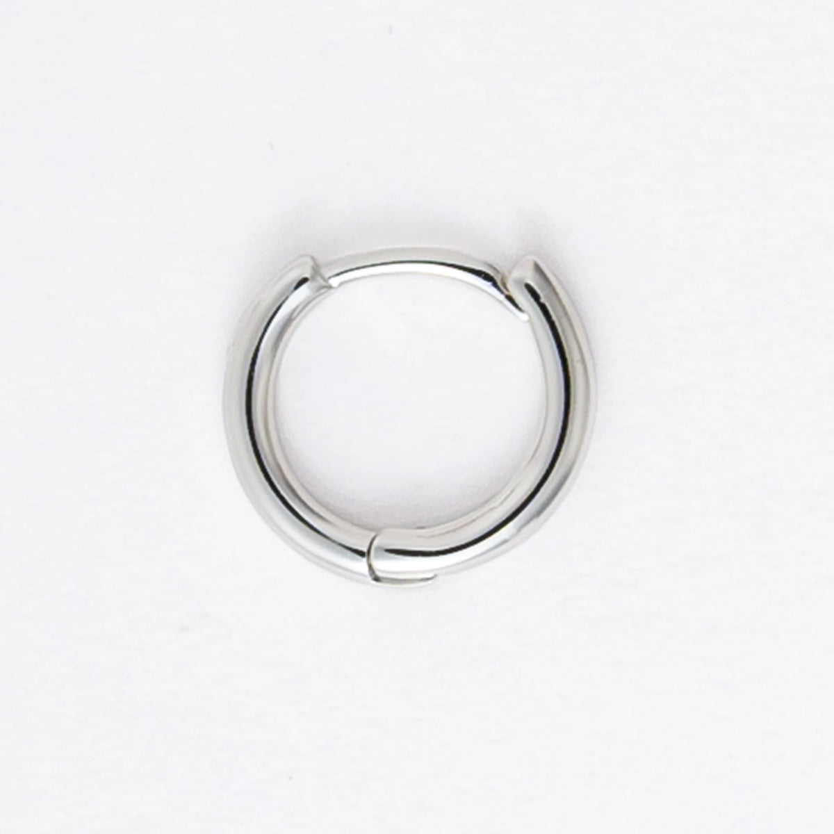 Two silver hoop earrings on a light gray background