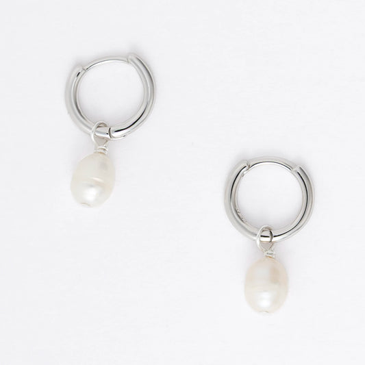 Pair of silver hoop earrings with pearl drops on a light gray background