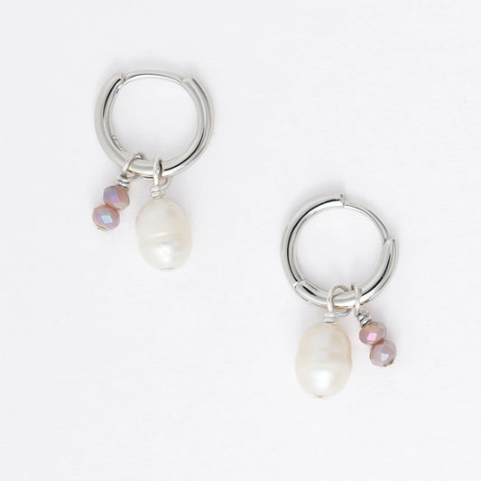 Pair of silver earrings with small pearls on a light gray background