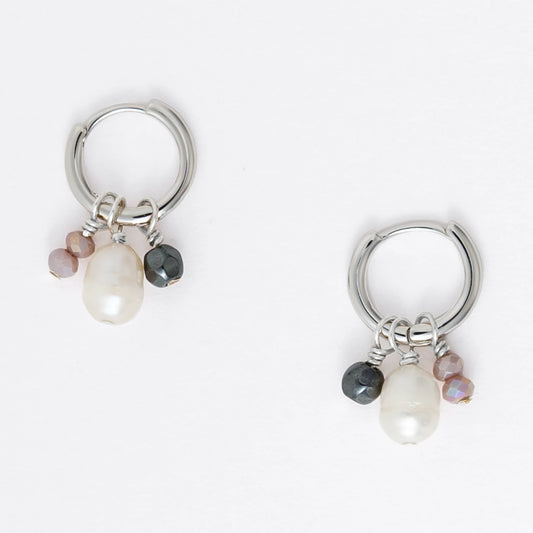 Pair of silver hoop earrings with pearls and a black bead on a white background
