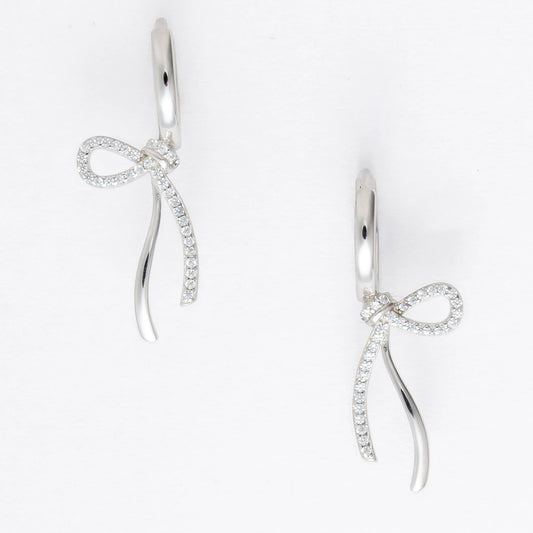 Pair of silver earrings with bow design on a light gray background