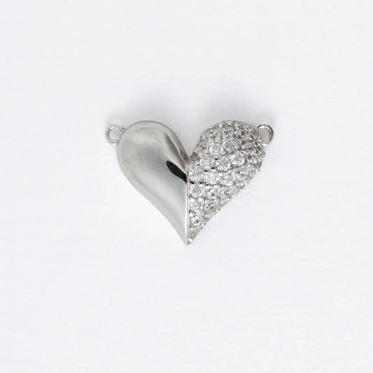 Silver heart-shaped charm on a light gray background
