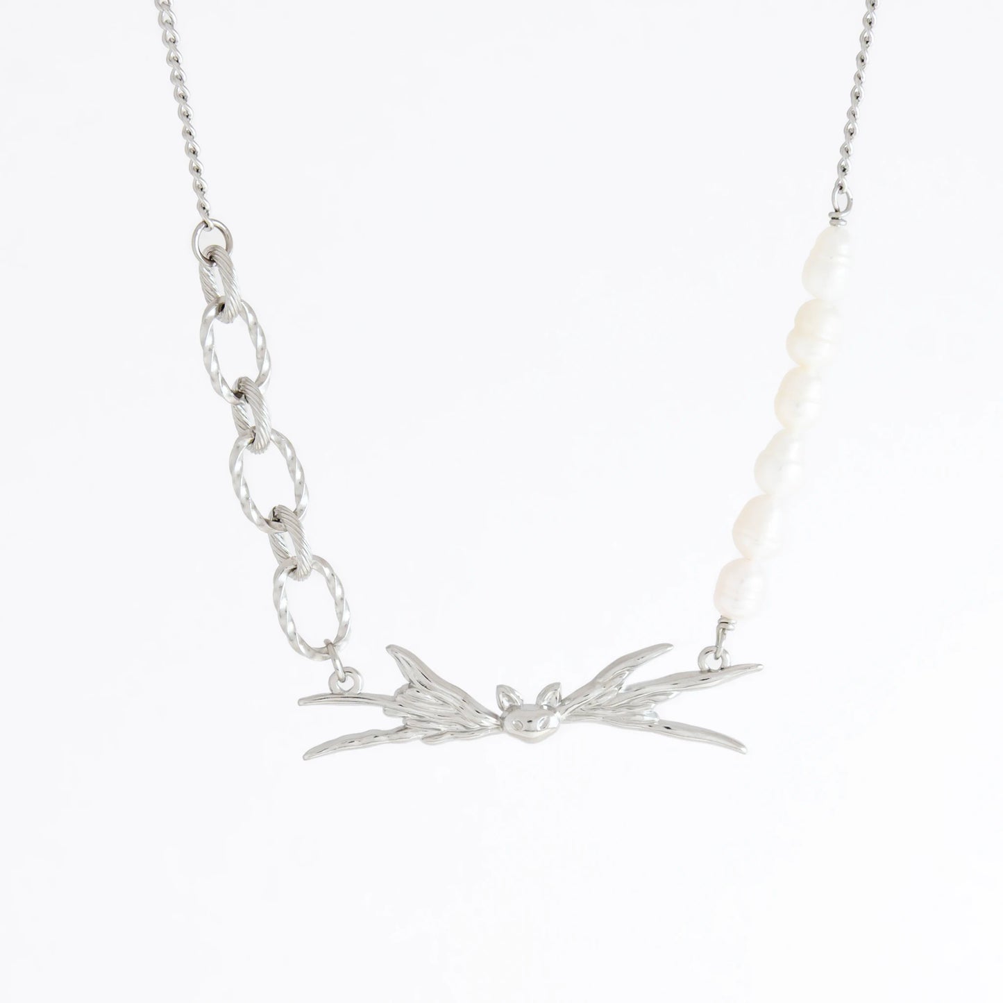 Silver necklace with leaf-like pendant on a white background