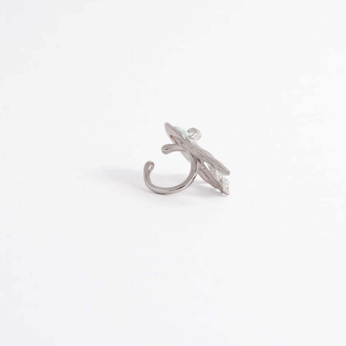 A silver-toned ring shaped like a stylized leaf with a curved hook-like base, photographed on a plain white background.