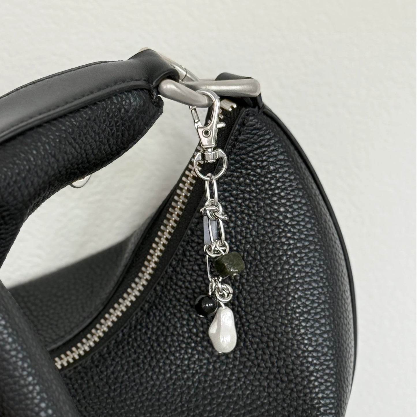 Multi-stone keychain hanging on a black purse