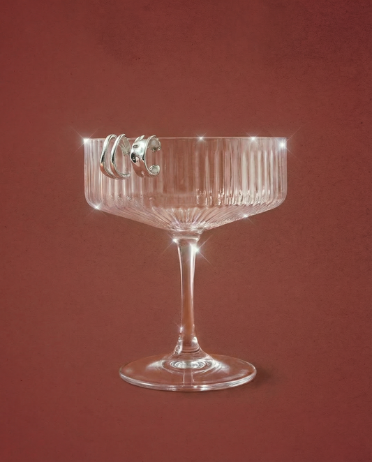 Sterling silver ear cuffs styled on a champagne glass with a red background
