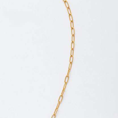 Gold paperclip necklace non-tarnish with a round sun pendant and a pearl on a light gray background