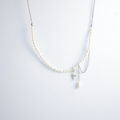 Pearl choker necklace with a small star pendant and a layering chain with pearl on a light gray background