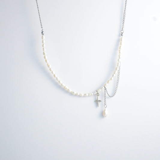 Pearl choker necklace with a small star pendant and a layering chain with pearl on a light gray background