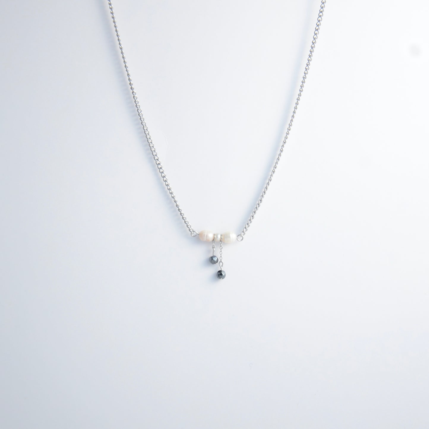 Silver necklace with a bow made of pearls and glass beads