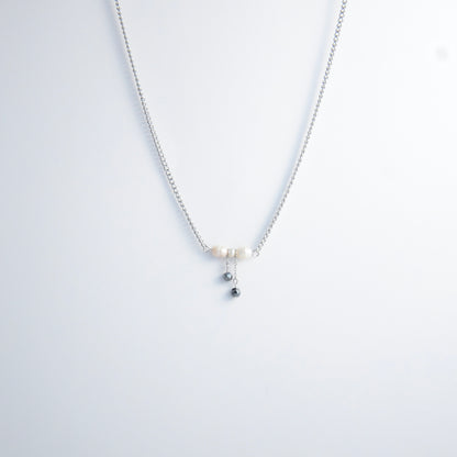 Silver necklace with a bow made of pearls and glass beads