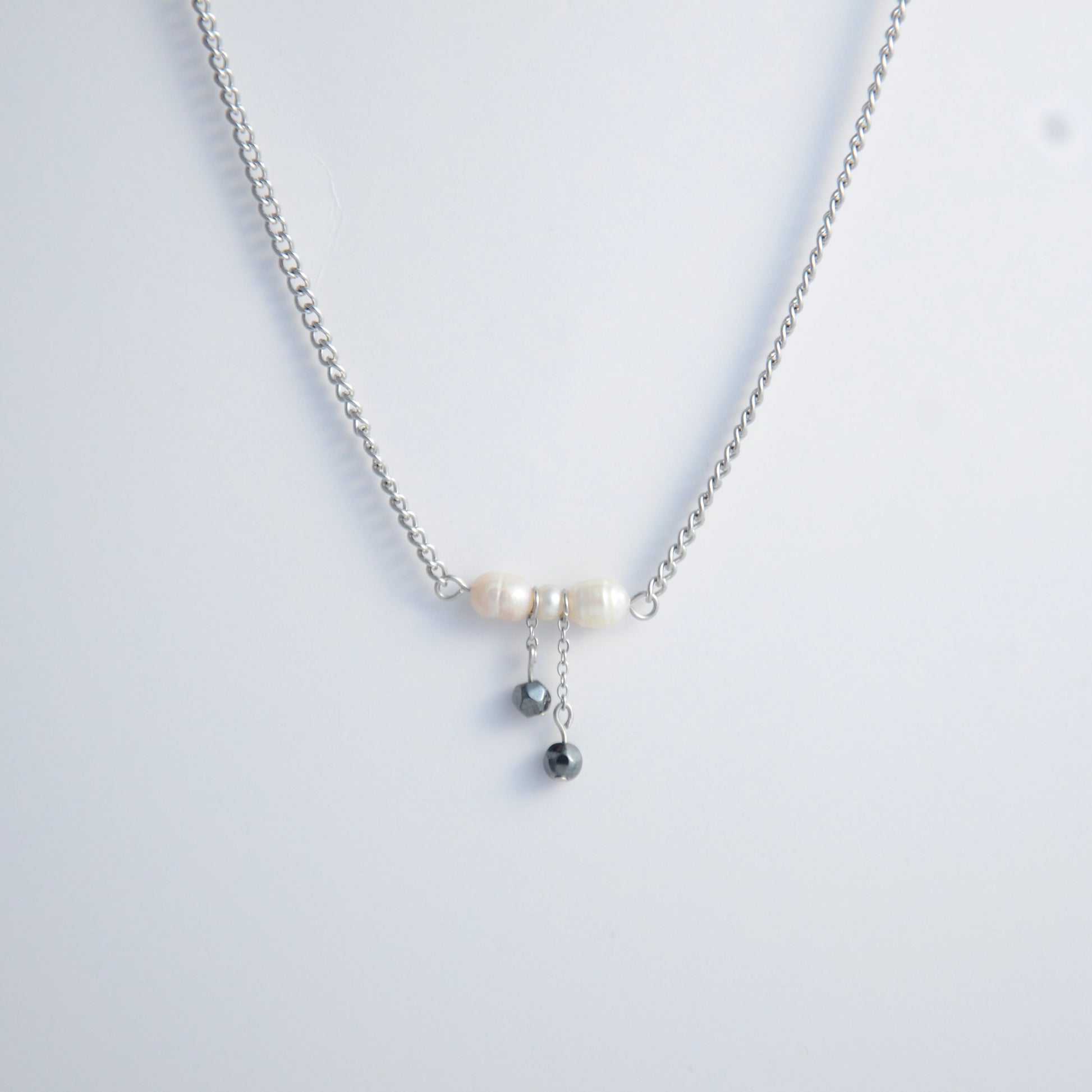 Silver necklace with a bow made of pearls and glass beads