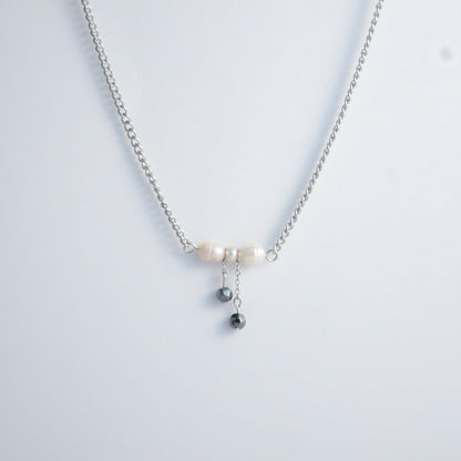 Silver necklace with a bow made of pearls and glass beads