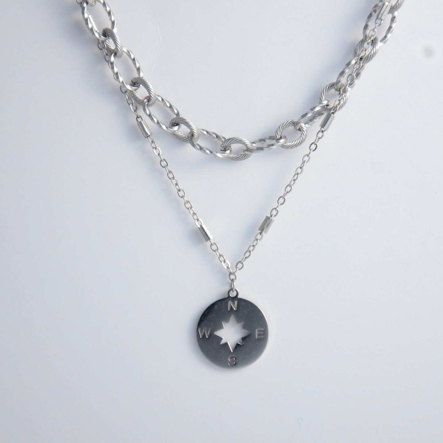Silver layered paperclip necklaces non-tarnish with compass charm on a light gray background