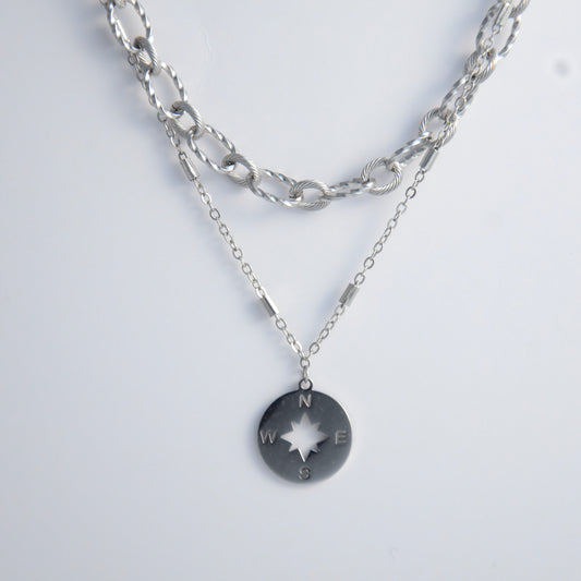 Silver layered paperclip necklaces non-tarnish with compass charm on a light gray background