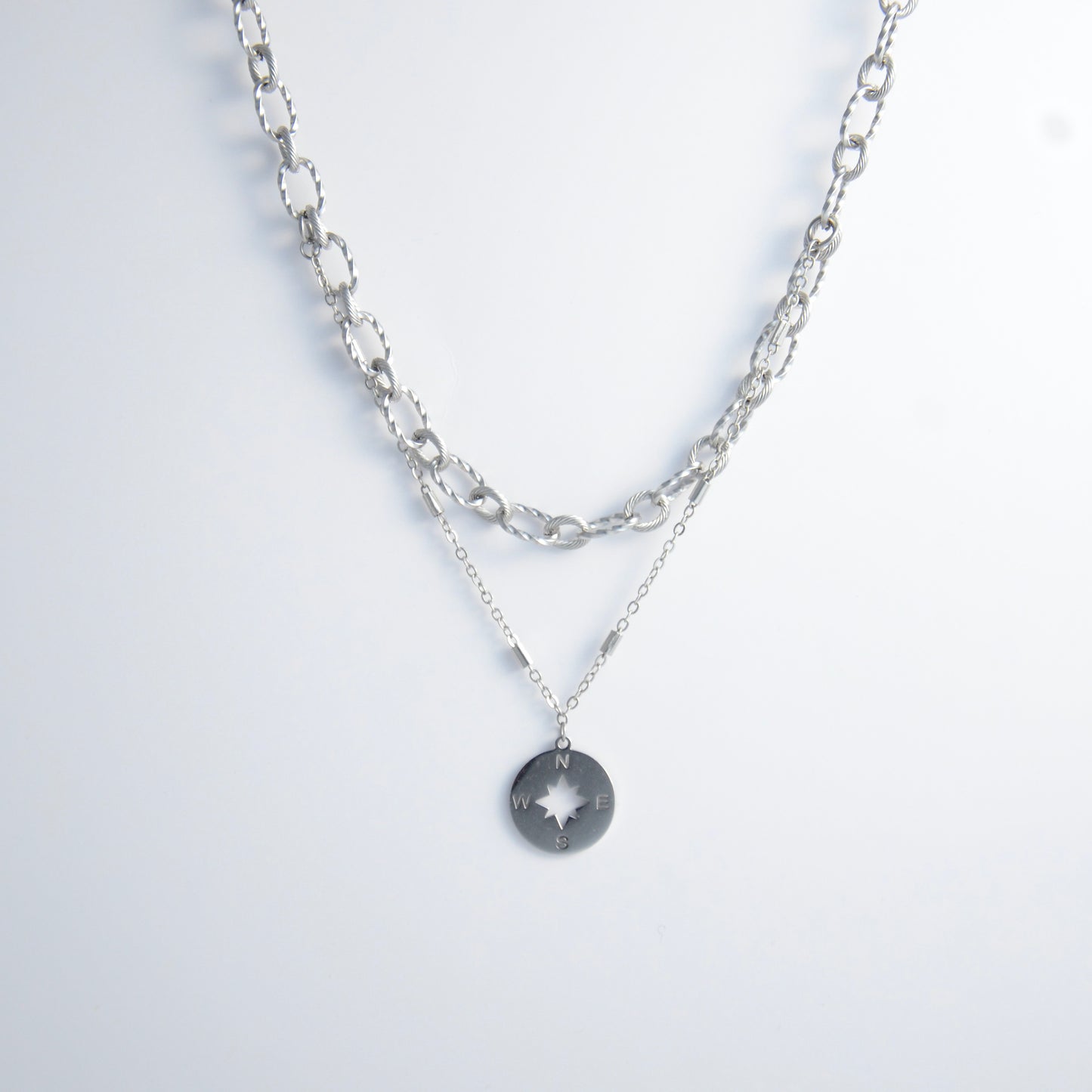 Silver layered paperclip necklaces non-tarnish with compass charm on a light gray background