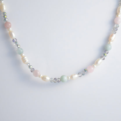 Beaded necklace with pearls and glass beads on a light gray background