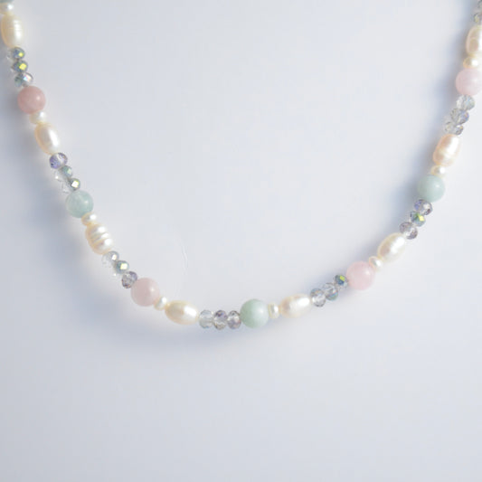 Beaded necklace with pearls and glass beads on a light gray background