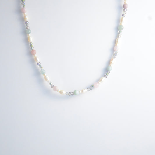 Beaded necklace with pearls and glass beads on a light gray background