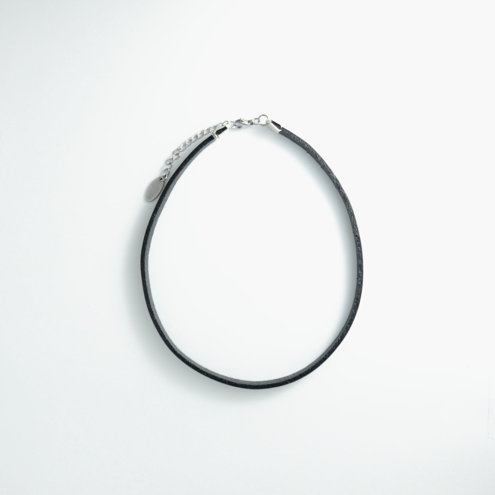 Black leather choker necklace on a light gray background