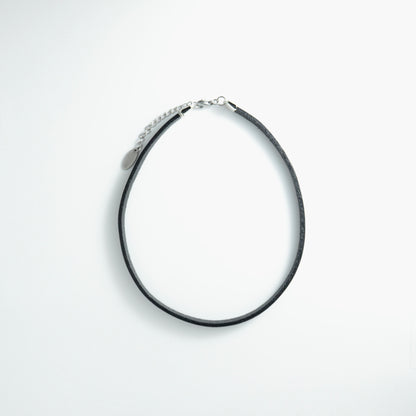 Black leather choker necklace on a light gray background