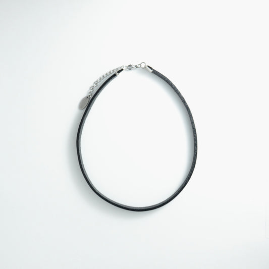 Black leather choker necklace on a light gray background