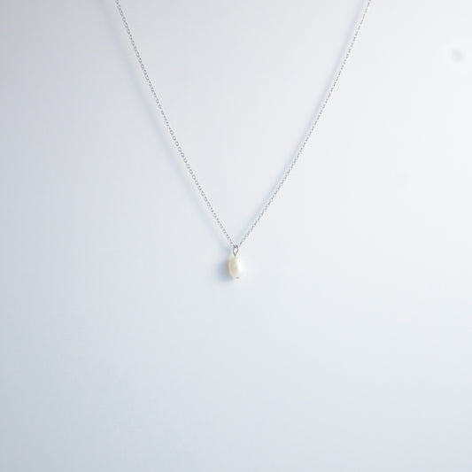 Silver dainty pearl necklace with freshwater pearl charm on a light gray background