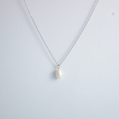 Silver dainty pearl necklace with freshwater pearl charm on a light gray background