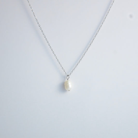 Silver dainty pearl necklace with freshwater pearl charm on a light gray background