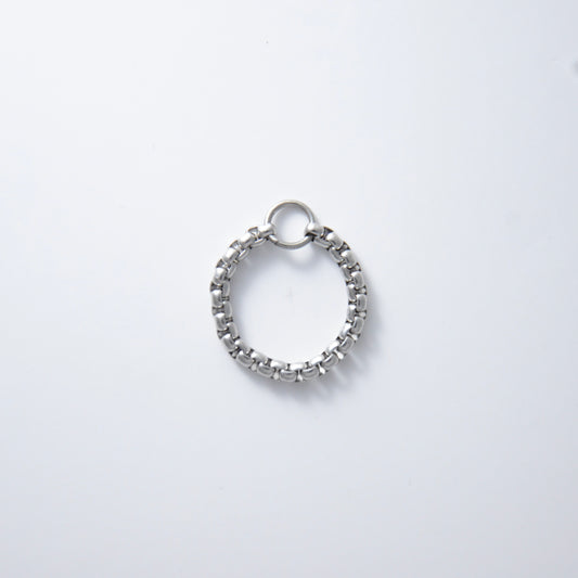 Silver stainless steel box chain ring on a light gray background non-tarnish geometric shape