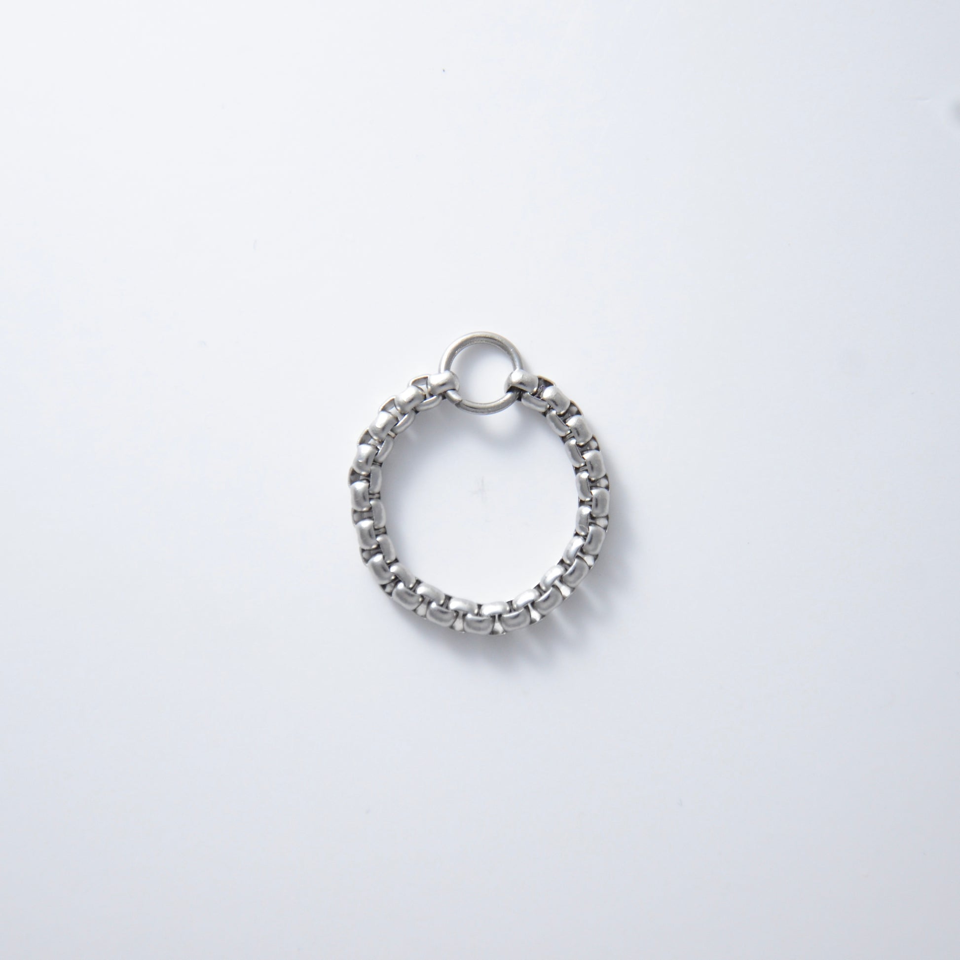 Silver stainless steel braided box chain ring on a white background
